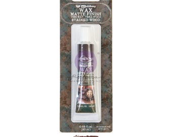 May include: A tube of Art Alchemy wax with a matte finish in Stained Wood. The tube is purple and white, and the packaging is brown and green. The tube contains 0.68 fl. oz. (20 ml) of wax.