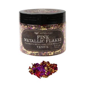 Könnte beinhalten: Ein durchsichtiger Kunststoffbehälter mit schwarzem Deckel, gefüllt mit feinen Metallflocken in Gold, Violett und Rot. Das Etikett trägt die Aufschrift Fine Metallic Flakes Venice 150 ml. Ein kleiner Haufen der Flocken liegt vor dem Behälter.