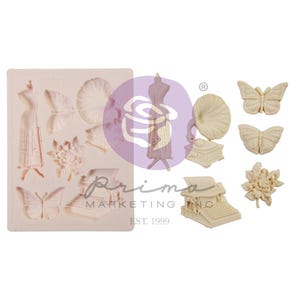 May include: A light beige silicone mold featuring various vintage-themed designs. The mold includes a dress form, butterflies, a gramophone, a typewriter, and floral elements. The Prima Marketing Inc. logo is visible.