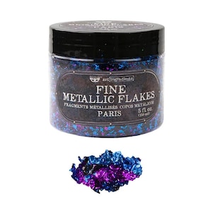 Könnte beinhalten: Ein durchsichtiger Kunststoffbehälter mit schwarzem Deckel, gefüllt mit feinen metallischen Flocken in Blau- und Violetttönen. Das Etikett trägt die Aufschrift Art Ingredients Fine Metallic Flakes Paris 5 fl. oz. (150 ml). Ein kleiner Haufen Flocken liegt davor.