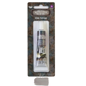 May include: A tube of "Old Silver" metallic wax by Art Alchemy. The product is in a clear tube with a white cap, packaged on a dark brown and teal card. The label includes the product name and volume: 0.68 fl. oz. (20 ml).