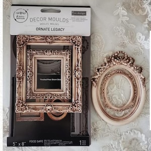 Könnte beinhalten: Eine Packung Dekorformen mit dem Text "ORNATE LEGACY" und einem dekorativen Rahmen. Die Packung ist 12,7 cm x 20,3 cm groß. Ein ovaler Rahmen mit dekorativem Rand ist ebenfalls abgebildet. Die Rahmen sind hellbeige.