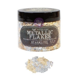 Könnte beinhalten: Ein durchsichtiger Kunststoffbehälter mit schwarzem Deckel, gefüllt mit goldenen und silbernen Metallflocken. Das Etikett trägt die Aufschrift METALLIC FLAKES SPARKLING 5 fl. oz. (150 ml). Ein kleiner Haufen der Flocken liegt vor dem Behälter.