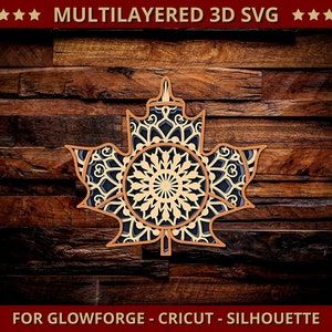 May include: A multilayered 3D SVG design of a maple leaf, featuring intricate patterns and a mandala-style center. The design is in shades of brown, beige, and navy blue, set against a dark wood background. Text at the top reads "MULTILAYERED 3D SVG" and at the bottom "FOR GLOWFORGE - CRICUT - SILHOUETTE".