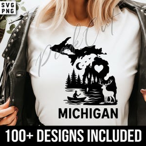 Może przedstawiać: Biała koszulka z czarną grafiką stanu Michigan, z sercem, jeleniem, drzewami i osobą w łodzi. Słowo "MICHIGAN" jest wydrukowane poniżej grafiki, z napisem "100+ DESIGNS INCLUDED" na dole.