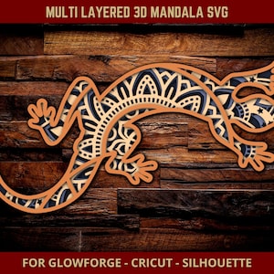 Może przedstawiać: Wielowarstwowy projekt SVG mandali 3D jaszczurki w odcieniach beżu, granatu i kremu. Obraz zawiera tekst "MULTI LAYERED 3D MANDALA SVG" i "FOR GLOWFORGE - CRICUT - SILHOUETTE". Projekt jaszczurki jest skomplikowany i szczegółowy.