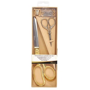 May include: Gold sewing scissors set in a box with a thimble, pins, and embroidery scissors. The box has the text "Professional Scissors Gift Set" and "Klasse".