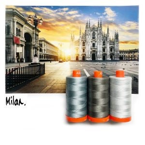Puede incluir: Tres carretes de hilo en tonos grises y plateados con tapas naranjas, sobre un fondo de un paisaje urbano con una catedral y el texto "Milan." Los carretes de hilo son cilíndricos y parecen llenos.