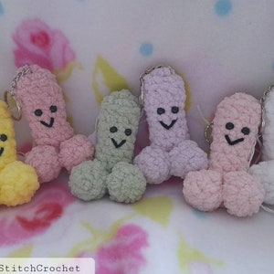 May include: A collection of six handmade crochet keychains in various pastel colors: yellow, pink, green, lavender, peach, and white. Each keychain features a smiling face and a silver keyring. The text "FreakyStitchCrochet" is visible at the bottom.