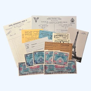 May include: A collection of vintage ephemera from World War II, including tickets, currency, and a postcard featuring the Eiffel Tower. The tickets are for the Empire Theatre, the Metropolitan subway, and a furlough pass. The currency is in French Francs. The postcard is in black and white and shows the Eiffel Tower against a cloudy sky.