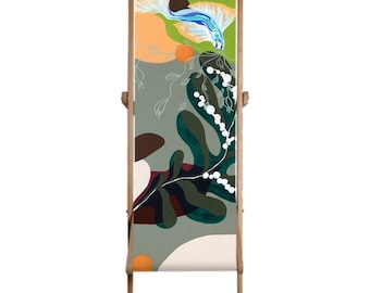 Op de afbeelding: Een houten vouwstoel met een kleurrijk abstract ontwerp met groen, blauw, wit en oranje. Het ontwerp bevat een gestileerde vis en bladerenranken.