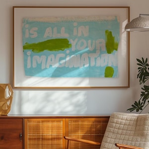 Può includere: Una stampa d'arte incorniciata con uno sfondo blu e testo bianco che recita "is all in your imagination". Il testo è dipinto in uno stile audace e astratto con accenti verdi.