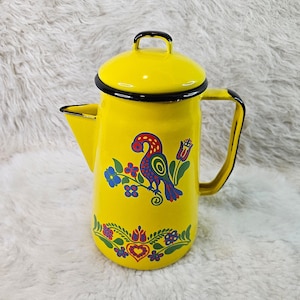 May include: Yellow enamel coffee pot with a black handle and a floral design featuring a bird, flowers, and a heart.