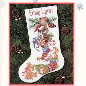 May include: A white Christmas stocking with the name "Emily Lynn" embroidered on the top. The stocking is decorated with a variety of woodland animals, including a raccoon, a squirrel, a mouse, and a rabbit. The animals are all wearing festive attire and are holding holiday decorations.