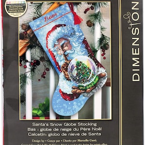 May include: A cross-stitch kit for a Christmas stocking, 40.6 cm long, featuring Santa Claus and a snow globe with a Christmas tree. The kit includes a thread organiser and instructions. The design is part of The Gold Collection.