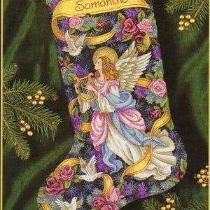 May include: A Christmas stocking with a dark blue background featuring a white angel playing a harp with gold ribbons and white doves. The stocking is decorated with pink and red roses and the name "Samantha" is written on a gold banner.