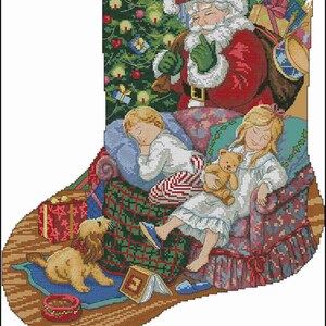 Puede incluir: Un calcetín navideño con un diseño de punto de cruz de Santa Claus detrás de dos niños durmiendo en un sillón con un perro, un árbol de Navidad y regalos. Debajo de la escena aparece el alfabeto completo en mayúsculas y minúsculas.