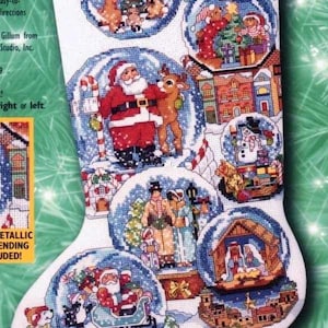 Könnte beinhalten: Ein Kreuzstichmuster für einen Weihnachtsstrumpf mit verschiedenen Schneekugeldesigns. Der Strumpf hat eine Schleife und den Namen "Ashley". Die Schneekugeln zeigen den Weihnachtsmann, Rentiere und Winterszenen.