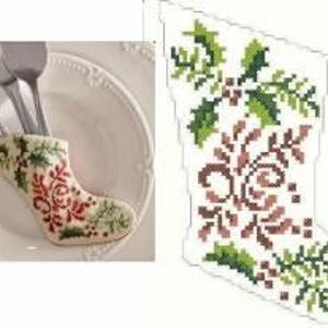 May include: A white Christmas stocking with a red and green floral design. The stocking is small and is used as a utensil holder.
