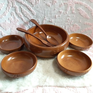 Puede incluir: Un juego de cinco ensaladeras de madera con una cuchara y un tenedor de servir de madera a juego. Los cuencos son todos marrones y tienen un acabado de madera natural. El juego es perfecto para servir ensaladas, aperitivos u otros platos.