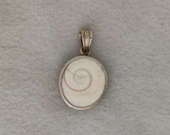 May include: A silver pendant featuring a white seashell with a spiral pattern.