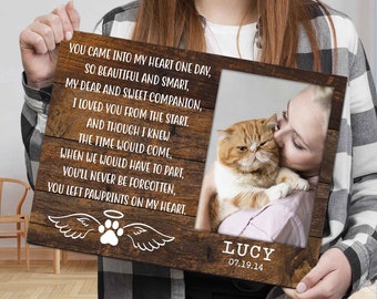 May include: A rectangular wooden memorial plaque featuring a dark wood grain finish. The left side displays a poem about a pet, a white paw print with angel wings, and a halo. The right side holds a photo of a cat and the name LUCY with 07.19.14.