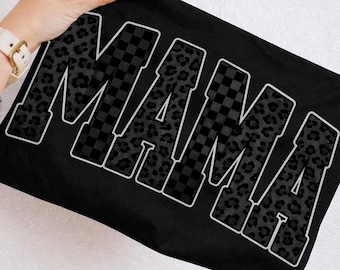 May include: Black tote bag with the word "MAMA" in large, bold letters. The letters alternate between a leopard print pattern and a black and white checkered pattern, outlined in white.