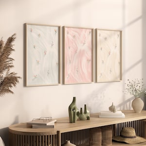 May include: Three framed illustrations of abstract patterns in blue, pink, and yellow with small figures scattered throughout.