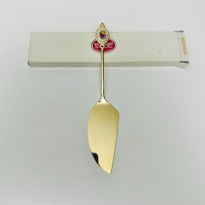 以下が含まれることがあります： 花柄のハンドルが付いたゴールドトーンのバターナイフ。ハンドルは、花柄と「ロイヤルアルバート オールドカントリーローズ」の文字が書かれた磁器の楕円形で飾られています。