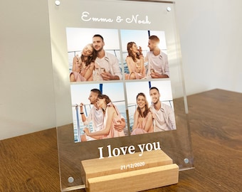 May include: A clear acrylic photo frame with a wooden stand. The frame holds four photos of a couple on a boat. The text "Emma & Noah" and "I love you 21/12/2020" is printed on the frame.