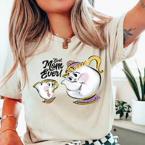 May include: A beige t-shirt with a graphic of two teacups from the Disney movie Beauty and the Beast. The text "Best Mom Ever!" is printed above the teacups.