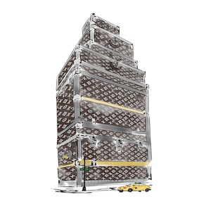 May include: A stack of five brown luggage trunks with a monogram pattern. The trunks are stacked on top of each other and are in the shape of a building. A yellow taxi cab is parked in front of the trunks.