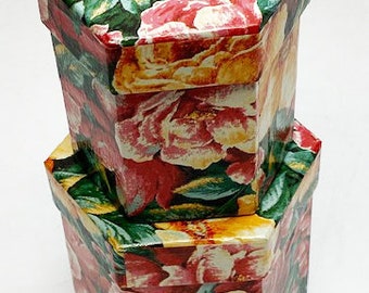 May include: Two hexagonal boxes with a floral pattern. The top box is red, yellow, and green with pink flowers. The bottom box is yellow, green, and red with yellow flowers.