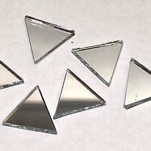 May include: Six silver triangular mirror tiles. The tiles are approximately 1 inch in size and have a slightly rough edge.
