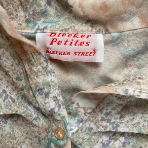 May include: A white and brown floral print shirt with a button closure. The shirt has a label that reads "Bleeker Petites by Bleeker Street."