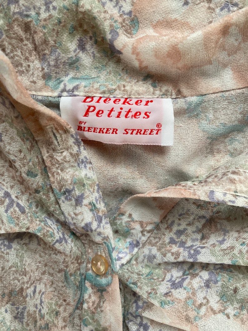 May include: A white and brown floral print shirt with a button closure. The shirt has a label that reads "Bleeker Petites by Bleeker Street."