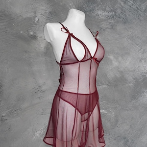 May include: A burgundy sheer lingerie dress with a delicate lace trim and bow accents.
