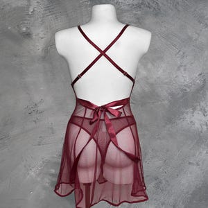 May include: A burgundy mesh slip dress with a satin ribbon tie at the back.