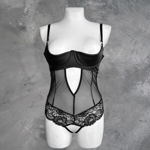 May include: Black lingerie with a lace bottom and a satin top. The top has a plunging neckline and adjustable straps.