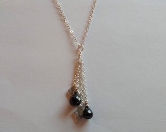 May include: A silver chain necklace with a silver pendant featuring three black teardrop-shaped stones.