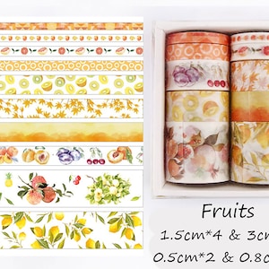 May include: A set of ten washi tapes featuring various fruit designs. The tapes are in a white box with the text "Fruits 1.5cm*4 & 3cm*2 0.5cm*2 & 0.8cm*2".