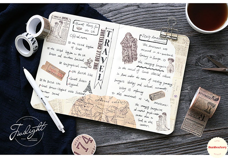 May include: A close-up of a notebook with a variety of decorative washi tapes, including a map, a vintage newspaper, and a floral design. The notebook is open to a page with handwritten notes about travel and history. The notebook is on a wooden surface with a cup of coffee and a pair of scissors.