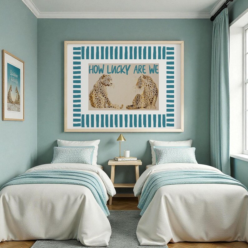 K&ouml;nnte beinhalten: Ein Schlafzimmer mit zwei Einzelbetten, jeweils mit wei&szlig;er Bettw&auml;sche und hellblauen Decken. &Uuml;ber den Betten h&auml;ngt ein gerahmtes Kunstwerk mit zwei Leoparden und dem Text "HOW LUCKY ARE WE". Die W&auml;nde sind in einem sanften T&uuml;rkis gestrichen.