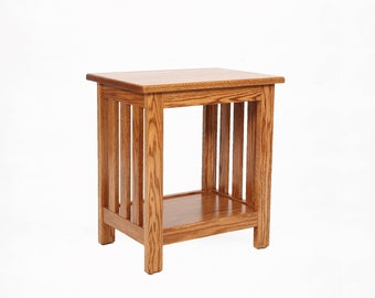 May include: A wooden side table with a square top and a lower shelf. The table is constructed with vertical slats on the sides and has a warm, natural wood finish. The table measures approximately 24 inches high.