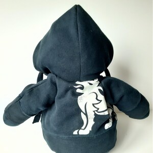 May include: Black plush hoodie with a white graphic of a lion with flames on its back.