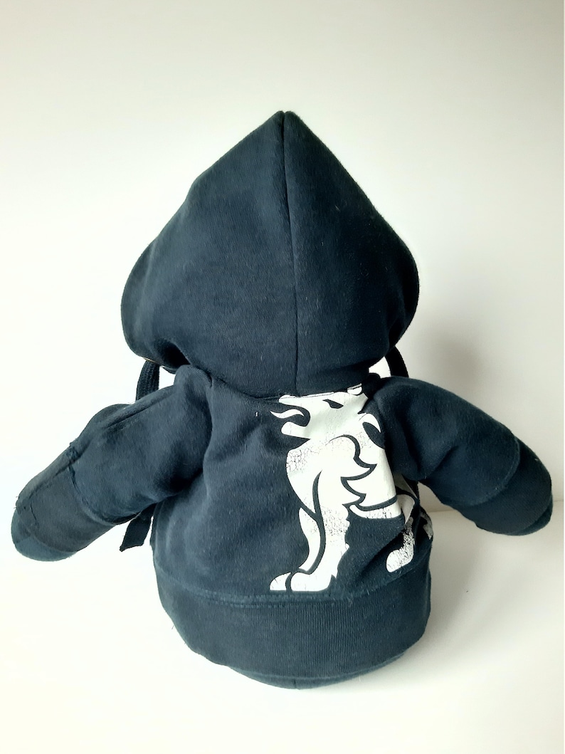 May include: Black plush hoodie with a white graphic of a lion with flames on its back.
