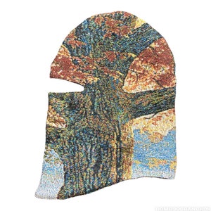 以下が含まれることがあります： 風景タペストリーデザインのバラクラバ。スキーマスクは、茶色、青、黄色の色合いの織り模様が特徴で、テクスチャード加工の外観を作り出しています。バラクラバには、目と口の開口部があります。