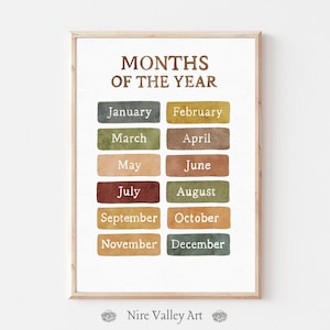 Op de afbeelding: Een ingelijste print met de tekst "MONTHS OF THE YEAR" in bruin. Elke maand wordt gepresenteerd in een rechthoekig blok met kleur, waaronder januari, februari, maart, april, mei, juni, juli, augustus, september, oktober, november en december.