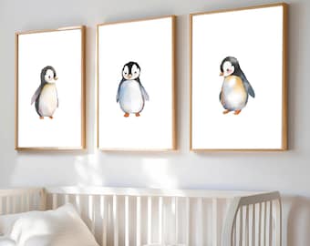 May include: Three framed watercolor paintings of penguins. Each painting features a single penguin with a white body, black head, and orange beak. The penguins are depicted in different poses, with one standing upright, one looking to the left, and one looking to the right.