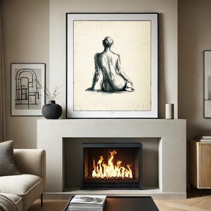 May include: A black and white sketch of a person sitting with their back to the viewer, framed and hanging above a fireplace with a fire burning inside.